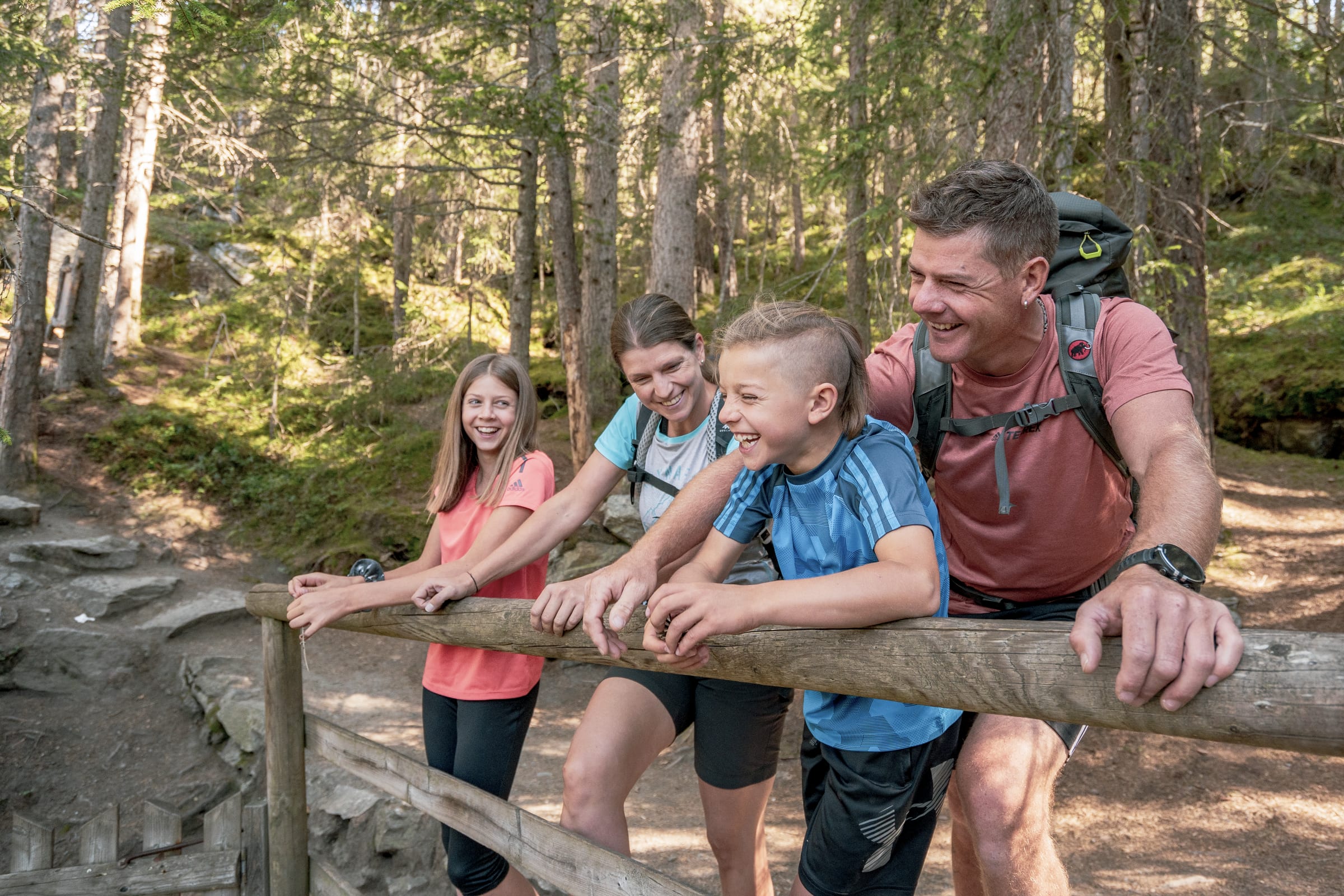 Familie mit zwei Kindern lacht auf einem Wanderweg im Ötztal