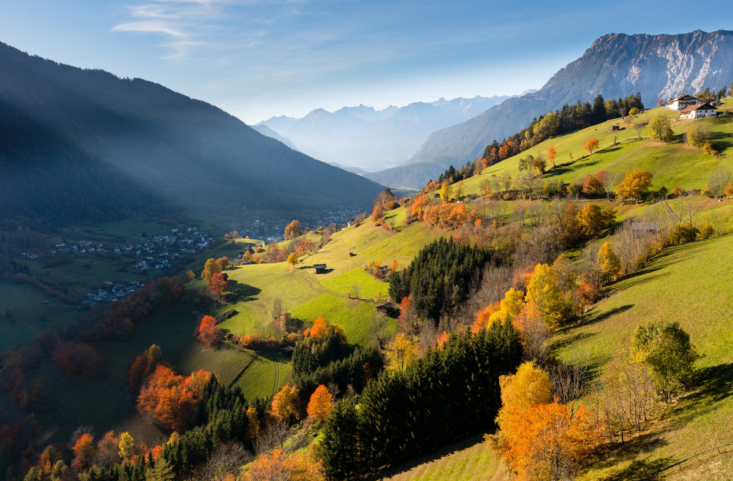 Goldener Herbst über Oetz im Ötztal mit verfärbten Wäldern und Bergen